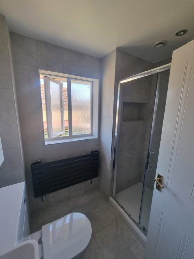 •Modern grey towel rail •Manhattan grey bathroom wall tiles •Toilet and basin combination unit •Contemporary bathroom design 